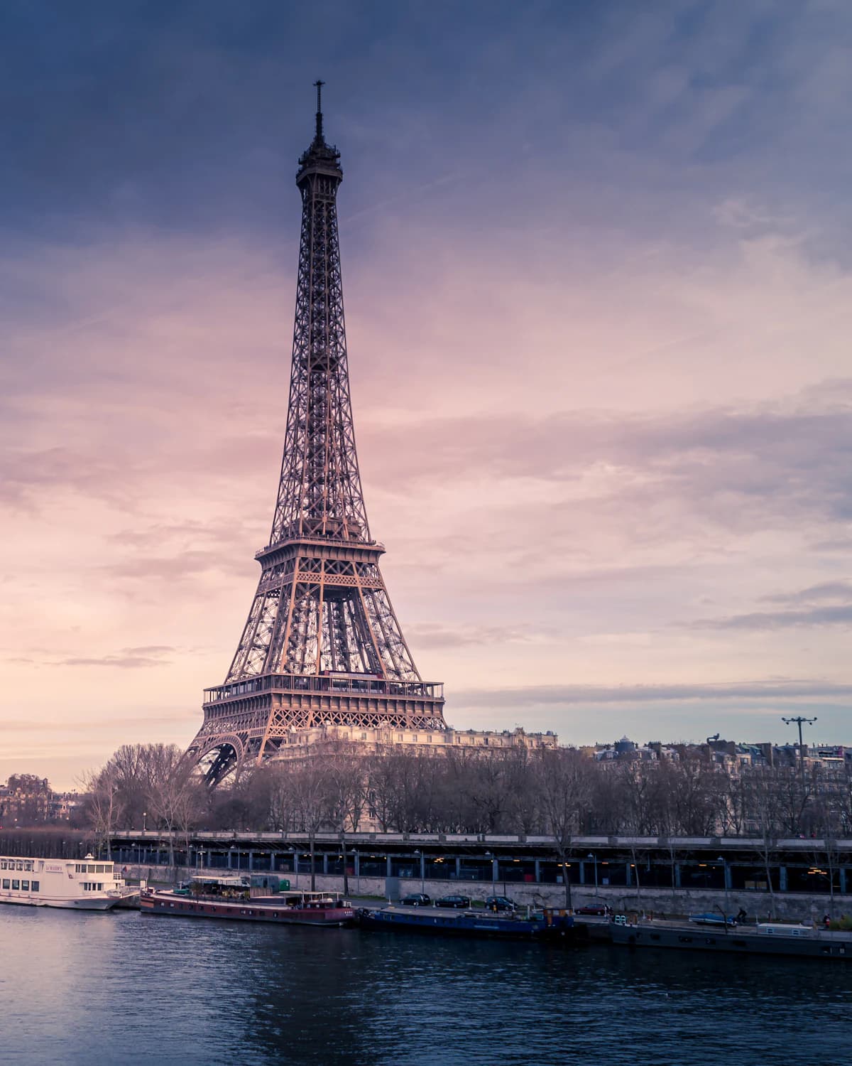 The Eiffel Tower and the Seine under a violet evening sky